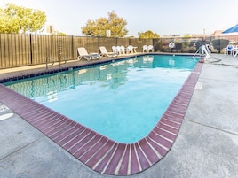 Una piscina al aire libre, tumbonas