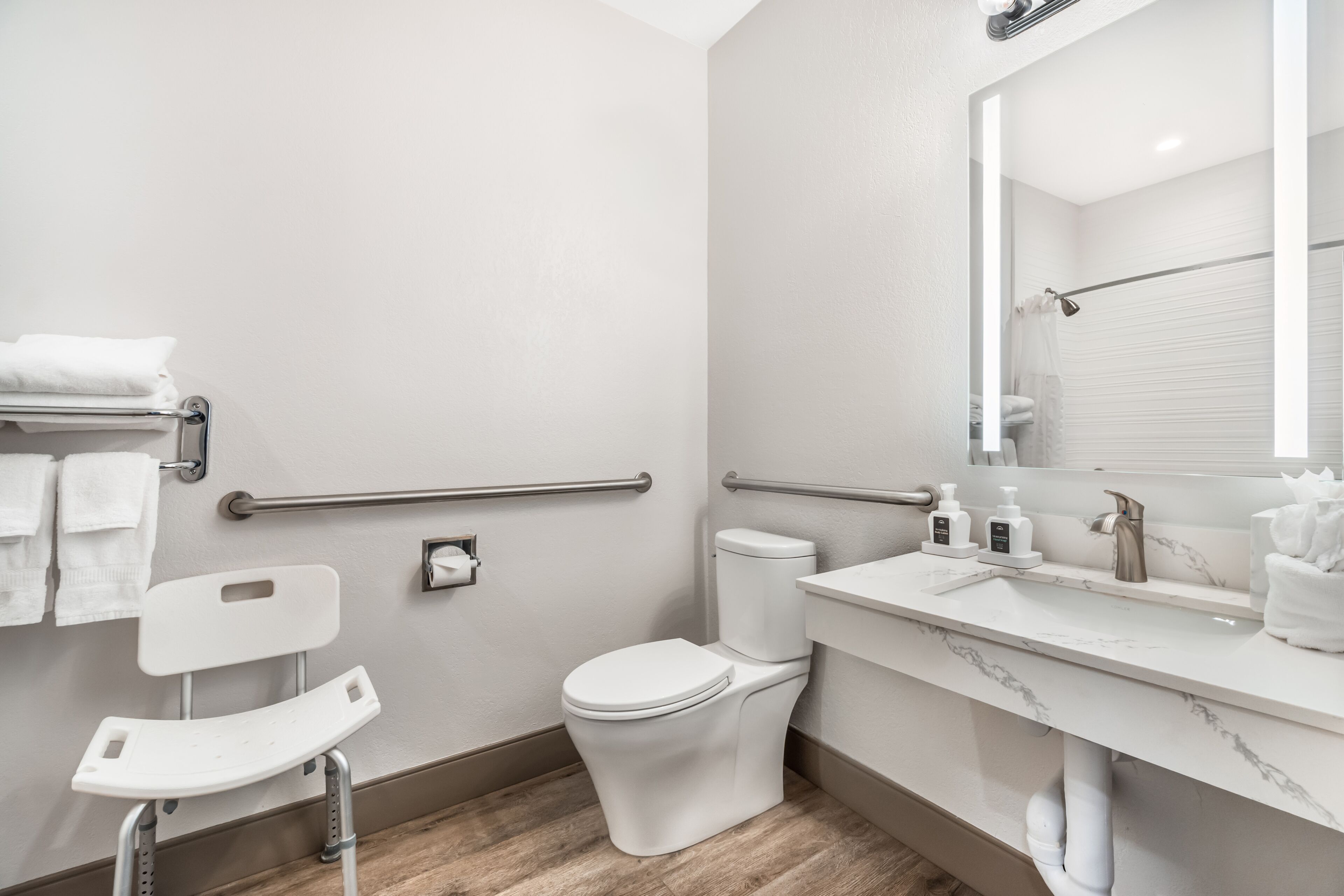 Un baño moderno con inodoro, bidé, secamanos y espejo.