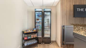 A kitchenette area with a water dispenser, a snack shelf, and a refrigerator.