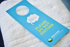 A blue tag with a hole, placed on a white towel.