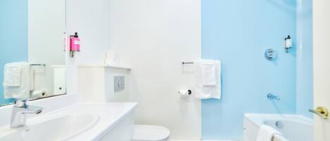 A modern bathroom with a white sink, toilet, and bathtub.