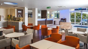 A modern hotel lobby with seating areas, a reception desk, and a view of the outside. - Holiday Inn Express London - Vauxhall Nine Elms by IHG (London)