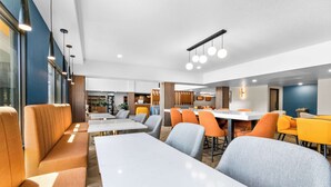Un comedor moderno con mesas altas y asientos cómodos.