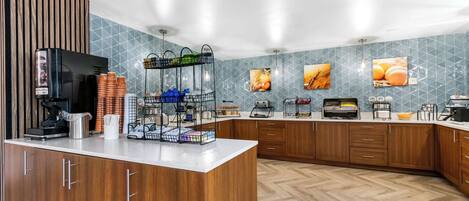 Una cocina moderna con armarios de madera, una estación de café y azulejos decorativos.