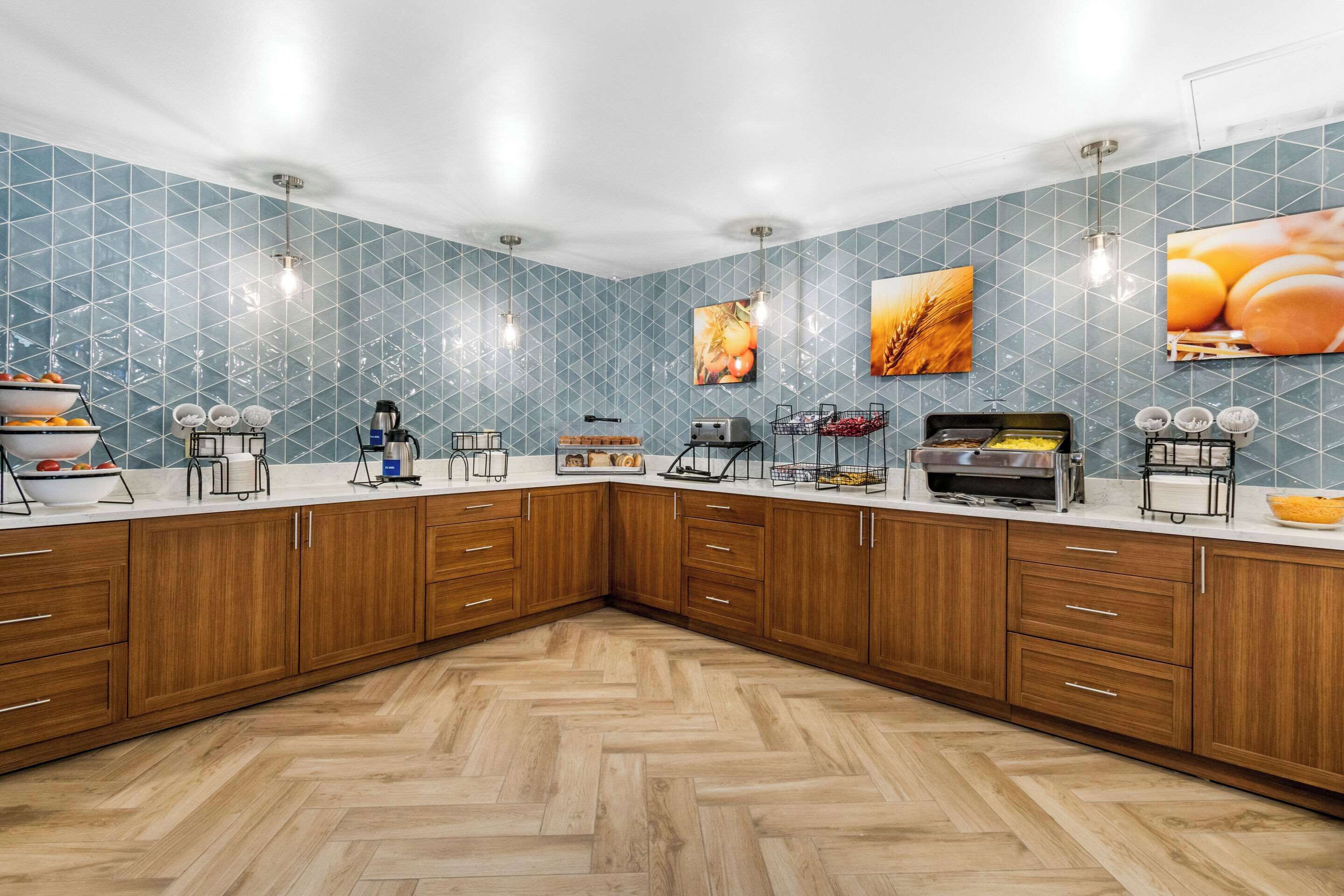 A kitchen with wooden cabinets, a herringbone floor, and tiled backsplash.
