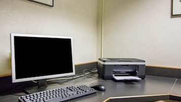 Et computerbord med en skærm, tastatur, mus og printer.