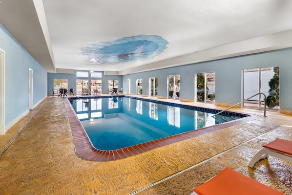 An indoor swimming pool with a clear blue water, surrounded by a sandy floor, and a ceiling mural. - Comfort Suites Goodlettsville Rivergate (Goodlettsville)