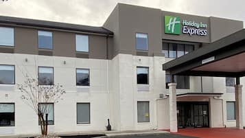 Un bâtiment de la chaîne Holiday Inn Express, doté d’un design moderne, avec un toit plat et un espace d’entrée abrité.