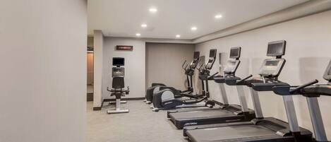 A gym with treadmills, ellipticals, and a stationary bike.