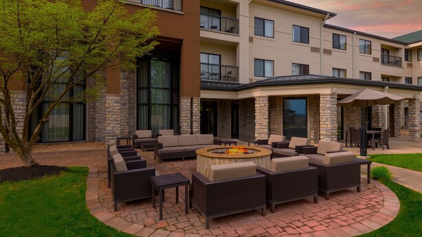 A courtyard with outdoor seating, a fire pit, and a building with multiple balconies. - Courtyard by Marriott Springfield Airport (Springfield)