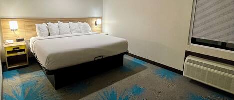 Una habitación de hotel con cama, mesitas de noche, televisión y ventana con persianas.