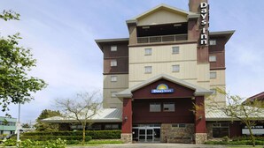 A Days Inn hotel with a prominent entrance, a balcony on the upper floor, and a clear sky.
