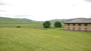 Paisatge rural amb un edifici de façana de maó i nombroses finestres.