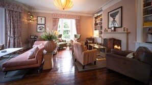 A cozy living room with a fireplace, comfortable seating, and a bookshelf. - Eleven Didsbury Park (Manchester)