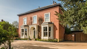 A two-story brick house with bay windows, a front entrance, and a driveway. - Eleven Didsbury Park (Manchester)