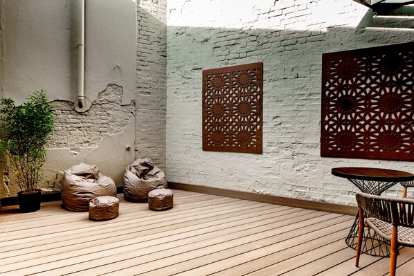 Relax in an outdoor space with a wooden deck, small table, and comfortable seating options.