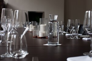 A table set with various glassware and a candle holder, indicating a formal dining arrangement.