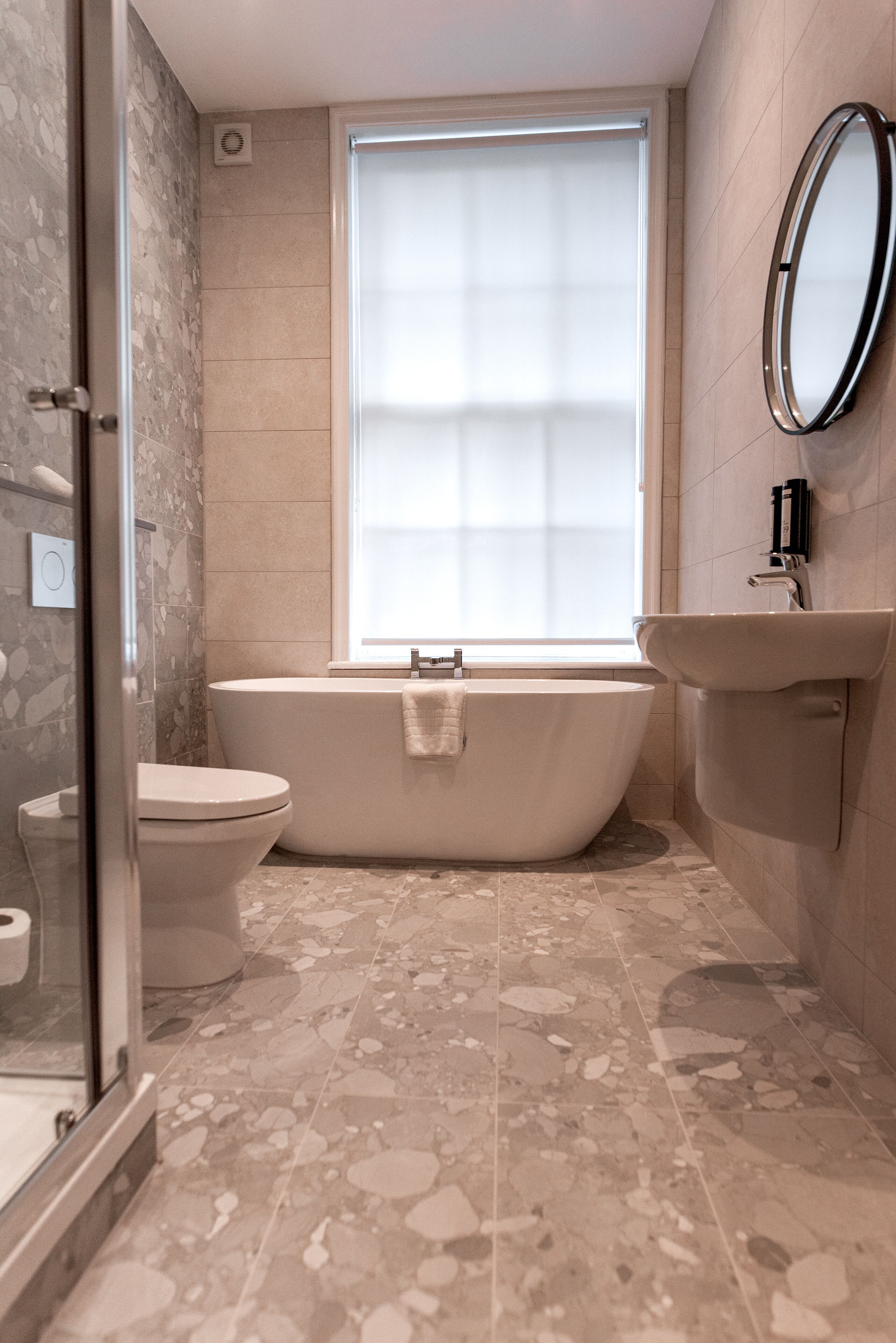A bathroom with a freestanding bathtub, a toilet, and a sink.