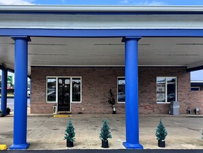 A building with a brick facade, blue columns, and a covered entrance.