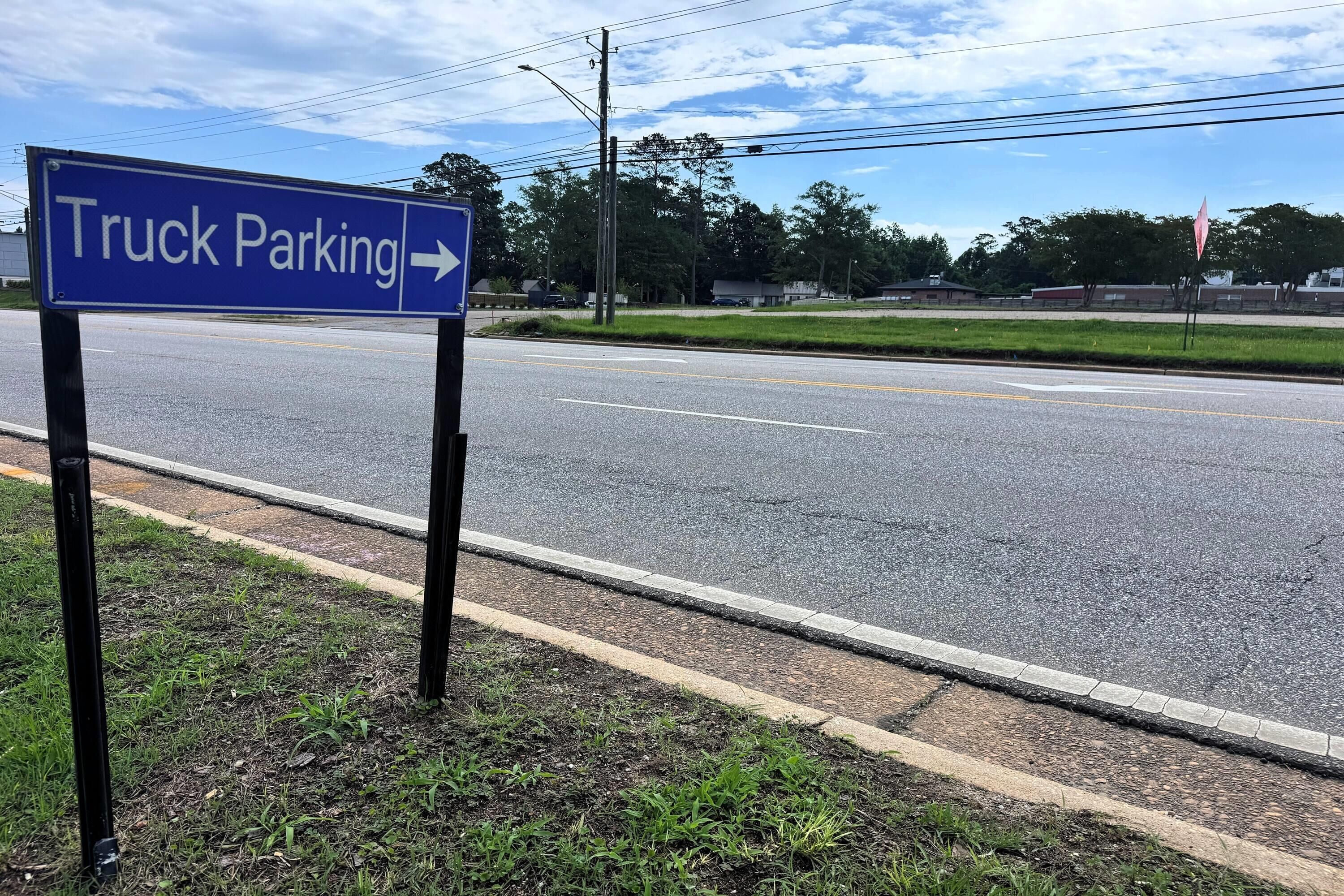 Señal de tráfico que indica estacionamiento para camiones a la derecha.