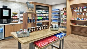 A modern retail space with wooden shelves stocked with various products, a display counter with jars, and a digital kiosk. - Embassy Suites by Hilton Columbus Dublin (Dublin)
