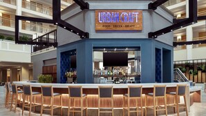 A bar area with a sign reading "URBAN CRAFT" and a bar counter with multiple stools. - Embassy Suites by Hilton Columbus Dublin (Dublin)