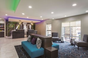 A modern lobby with a reception desk, seating area, and large windows. - La Quinta Inn & Suites by Wyndham Hopkinsville (Hopkinsville)