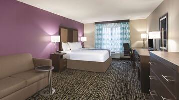 Ein Hotelzimmer mit Bett, Sofa, Schreibtisch und Kommode.