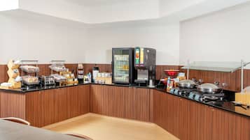 A modern kitchen with a built-in coffee machine, a refrigerator, and a glass display case.
