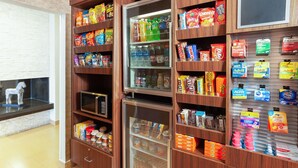 A vending machine stocked with snacks, drinks, and personal care items in a retail setting.