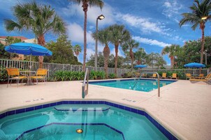 Una piscina al aire libre, sillones reclinables de piscina