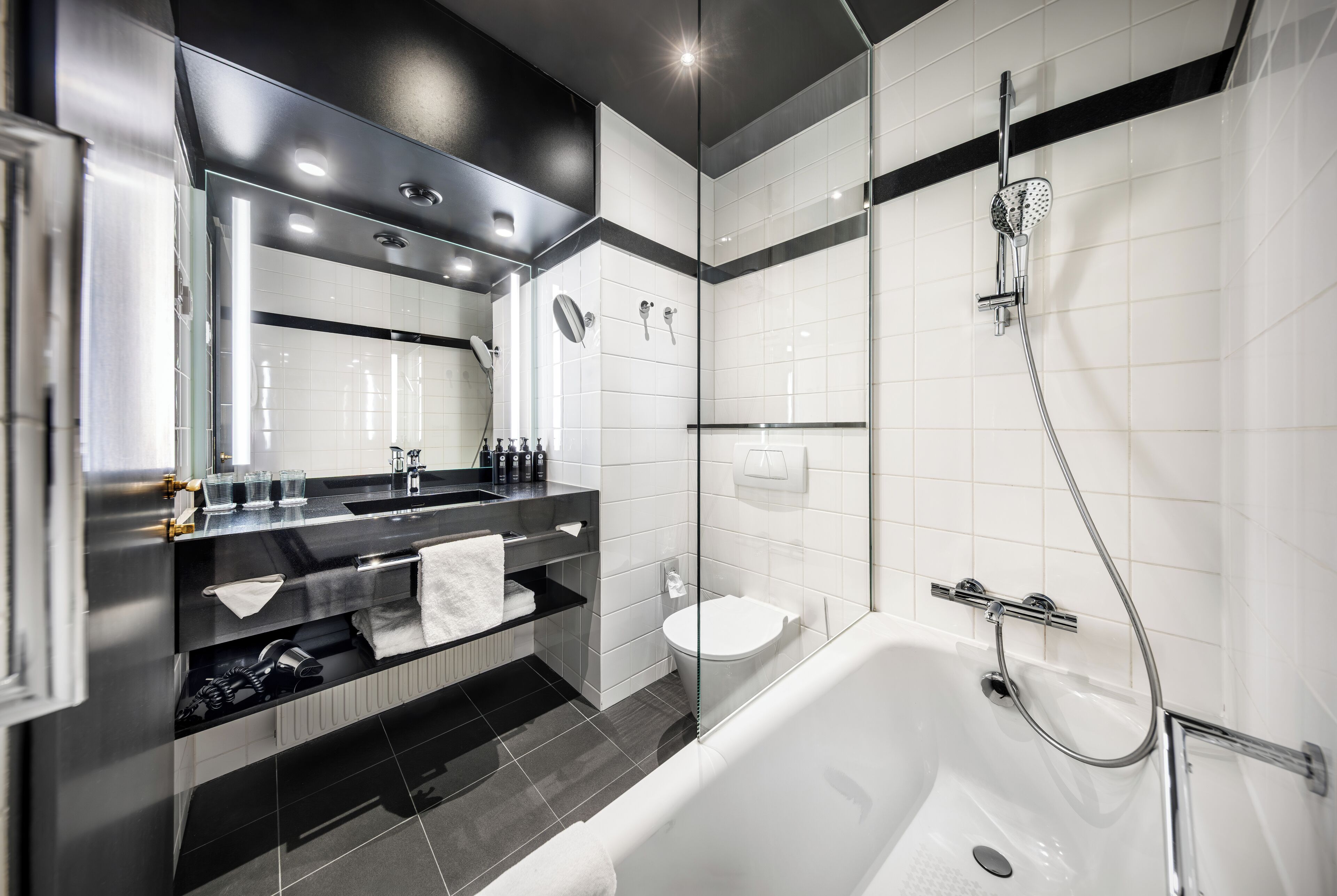 Un baño moderno con ducha de vidrio, inodoro separado y bañera.