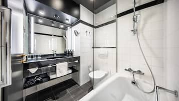 Un baño moderno con ducha de vidrio, inodoro separado y bañera.