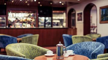 Una zona de bar con una mesa de centro, sillas y una cafetera.