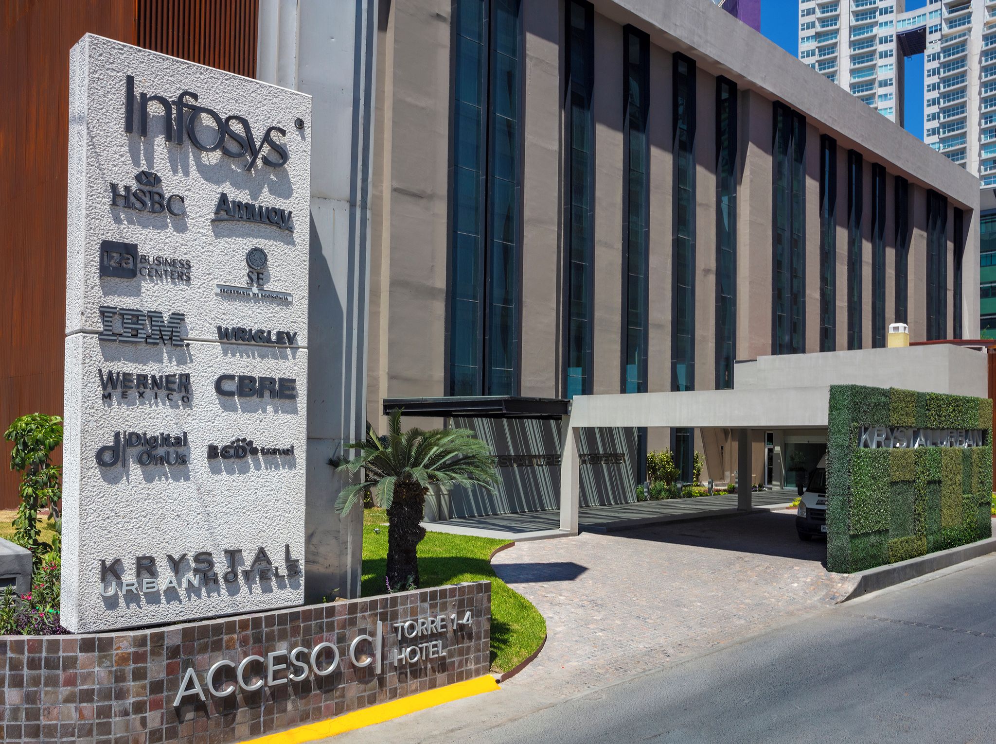 A hotel entrance with a sign listing various brands like HSBC, Amway, and IBM.