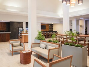 A modern lobby with seating areas, a bar, and a reception desk. - Krystal Urban Monterrey (Monterrey)