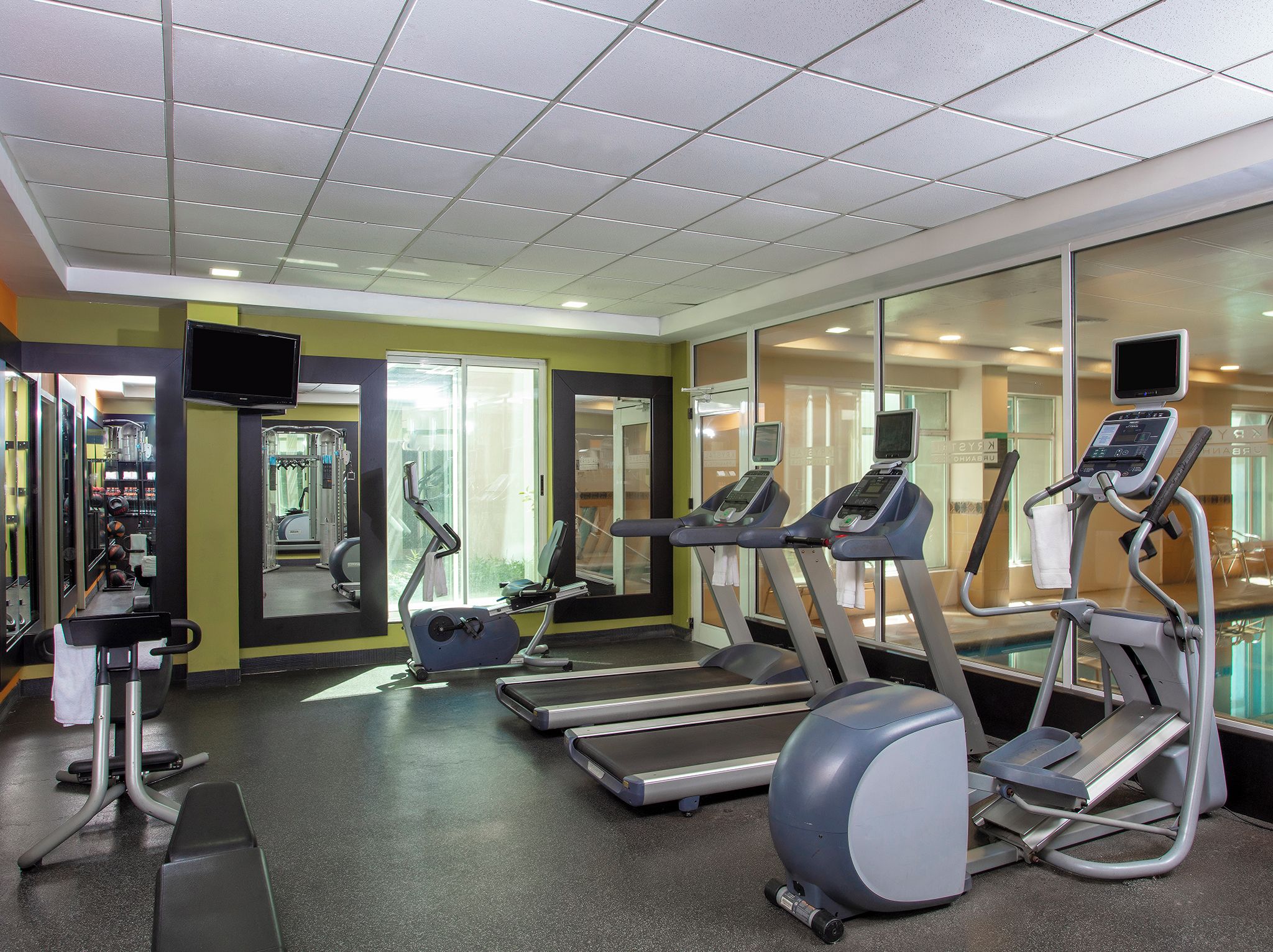A gym with treadmills, elliptical machines, and weight equipment.