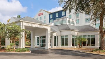 A Hilton Garden Inn with a covered entrance, multiple windows, and a parking lot.