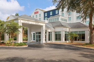 A Hilton Garden Inn with a covered entrance, multiple windows, and a parking lot.