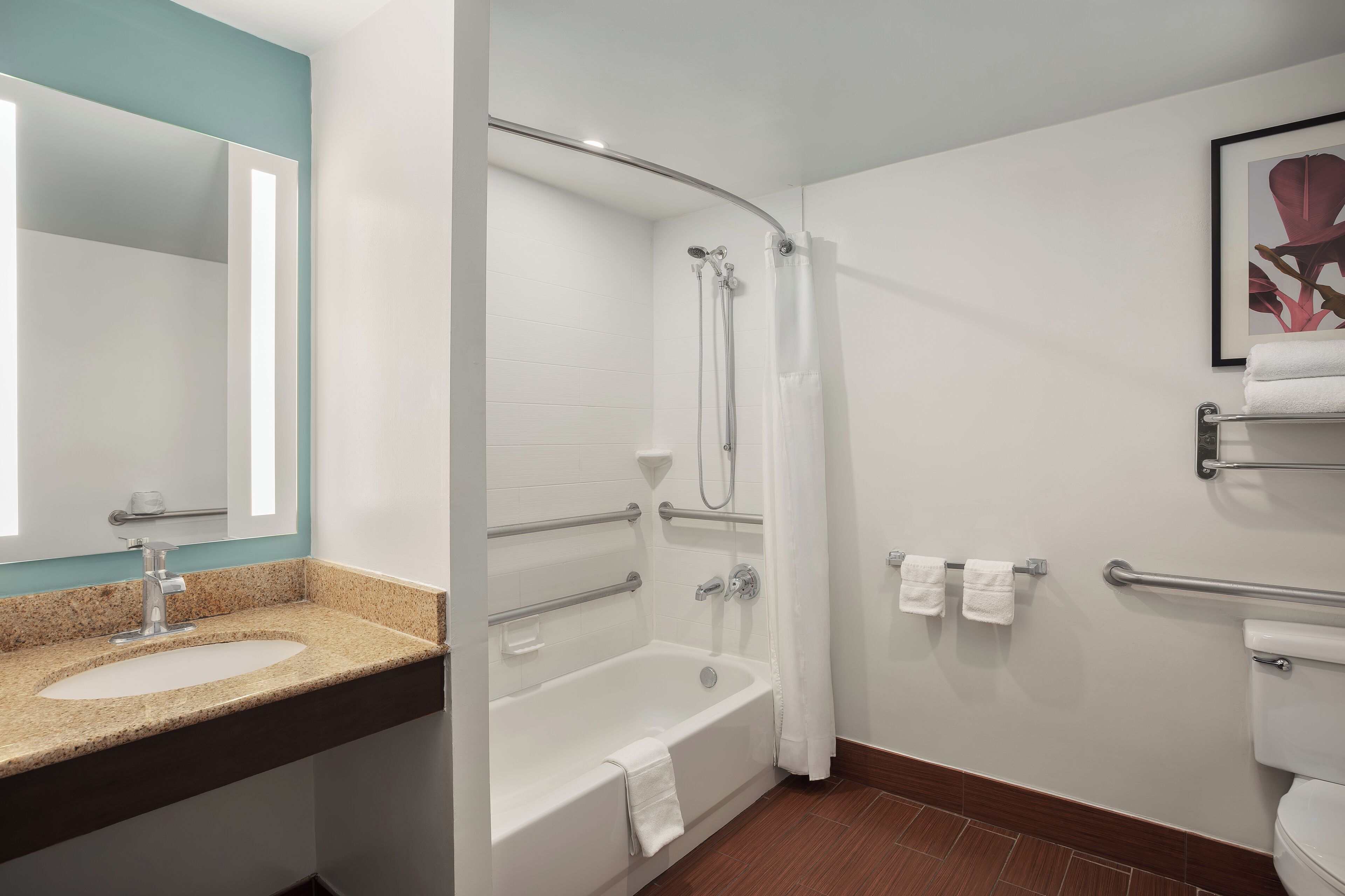 A modern bathroom with a sink, bathtub, and toilet.