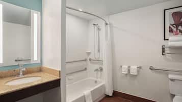 A modern bathroom with a sink, bathtub, and toilet.