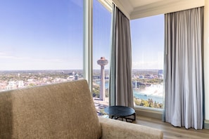 A room with a large window, a sofa, and a small table.