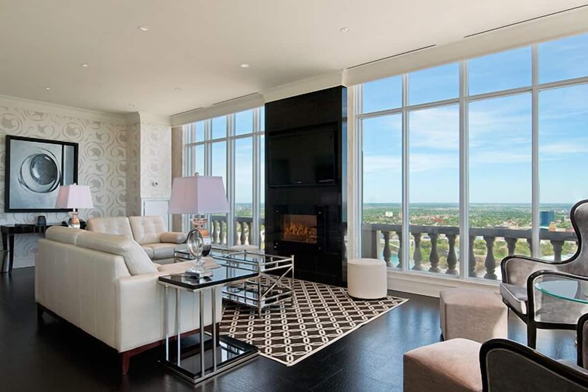 Un salon moderne doté d’une cheminée, de grandes fenêtres et d’un balcon offrant une vue imprenable.