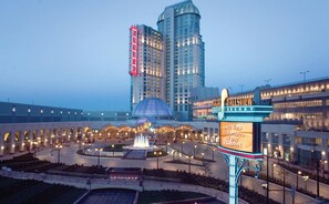 A hotel with a large fountain, a casino sign, and modern buildings in the background.