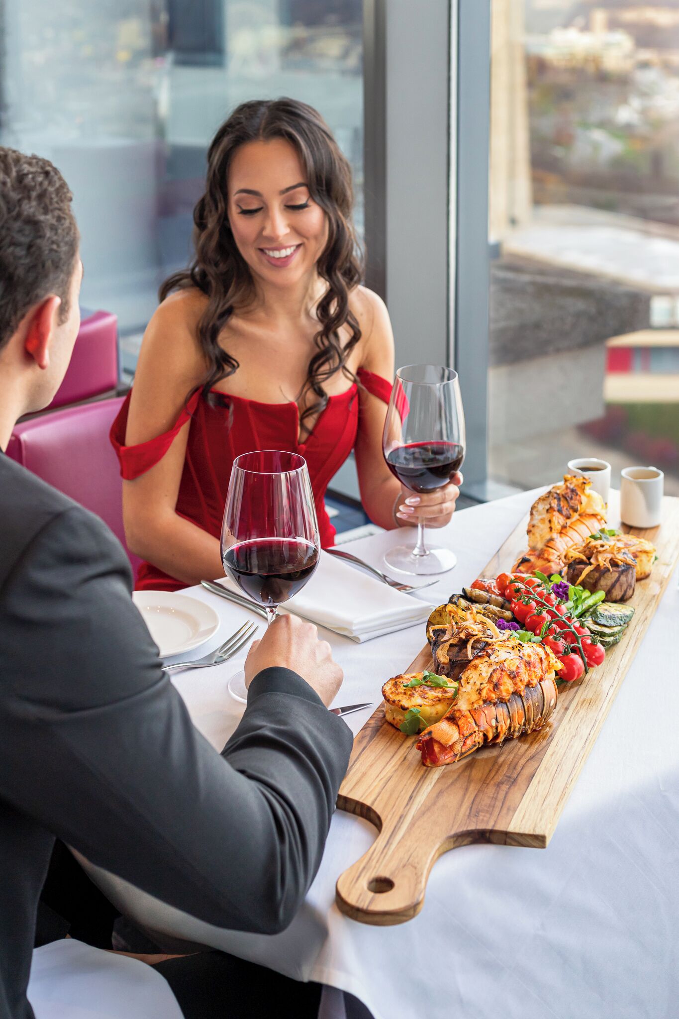 A couple dining at a table with a wooden board displaying a variety of dishes.