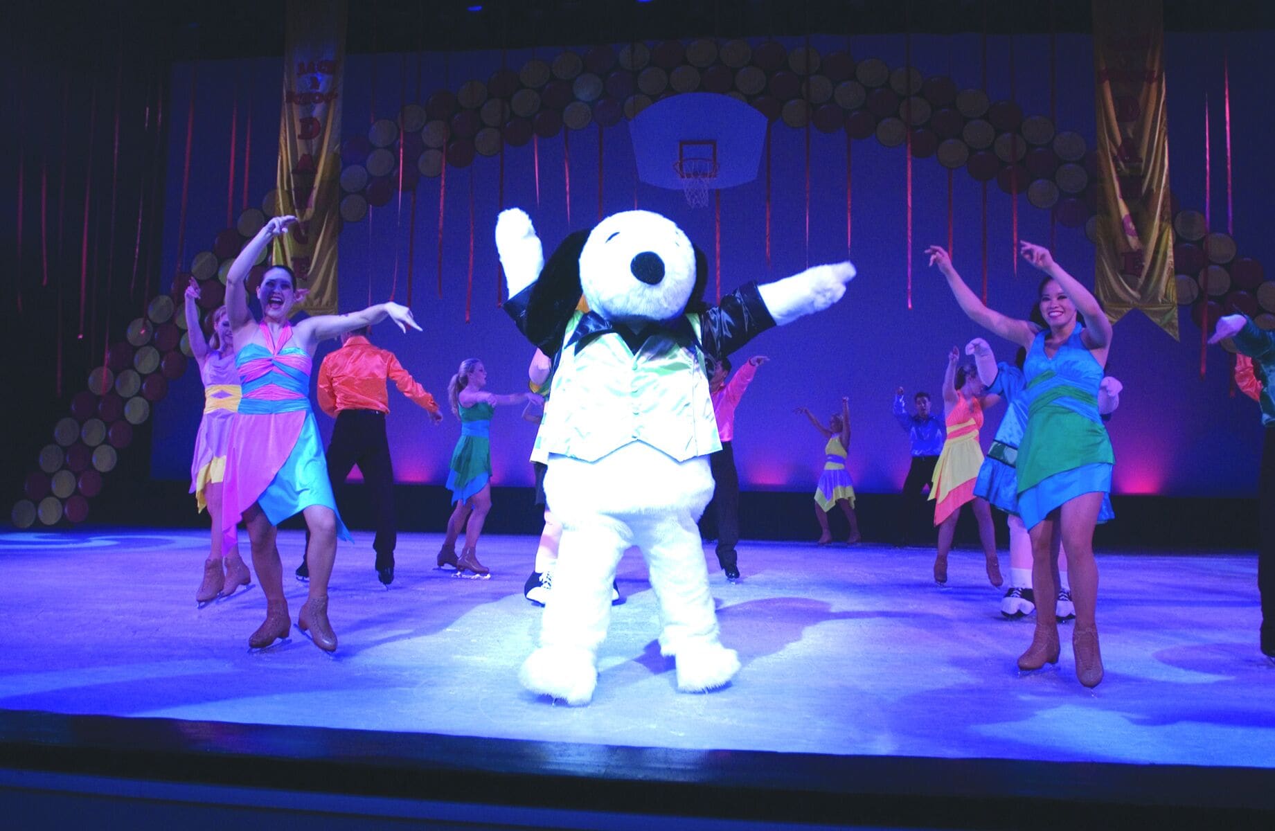 A stage with a mascot and dancers performing.