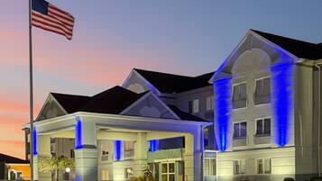 A hotel with a large entrance and a flagpole with an American flag.
