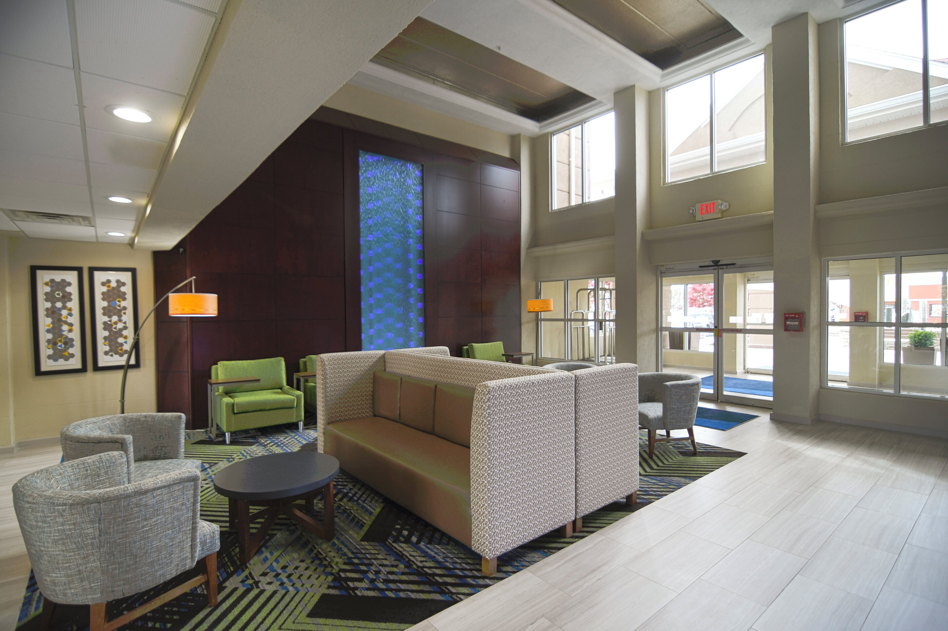 A lobby with a high ceiling, a large window, and a reception desk.
