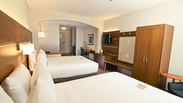Une chambre d’hôtel avec deux lits, un bureau, une chaise, une télévision et une armoire.