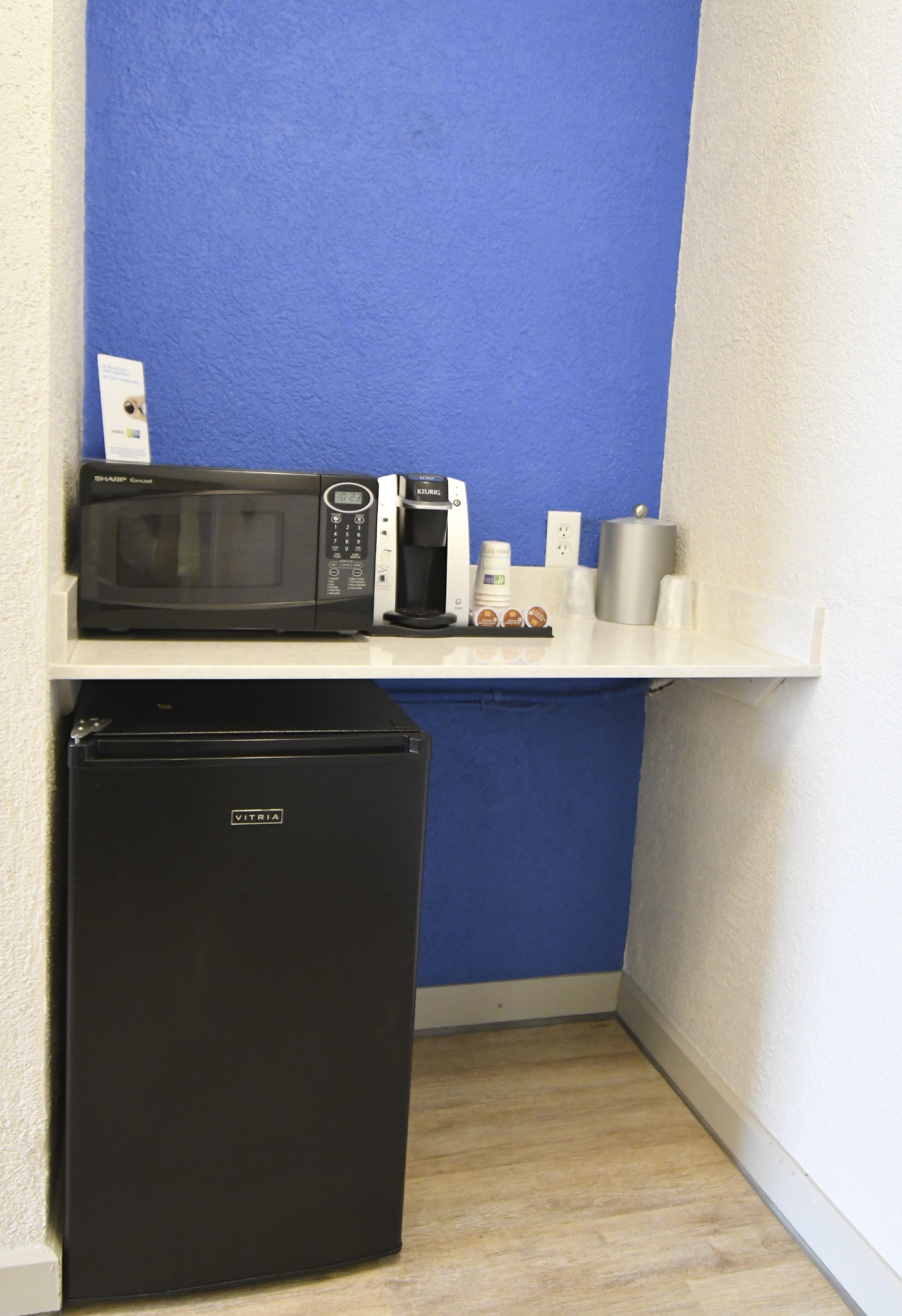 A kitchenette with a microwave, coffee maker, and a refrigerator.